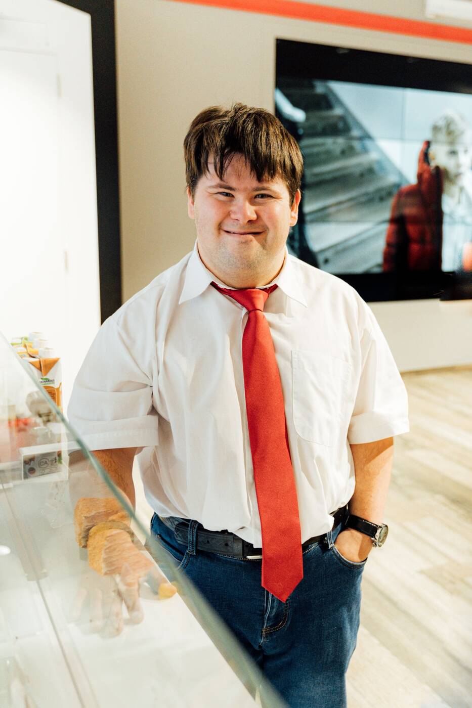A smiling employee standing confidently at work